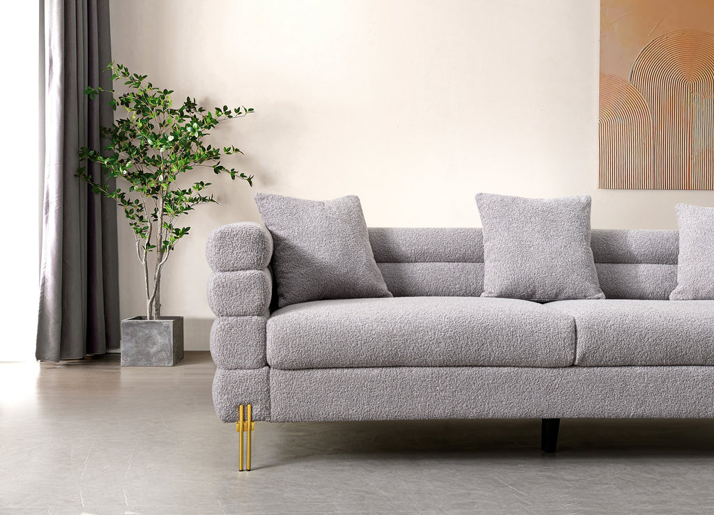 Luxurious and comfortable upholstered sofa with golden legs and pillows for living room and reception area