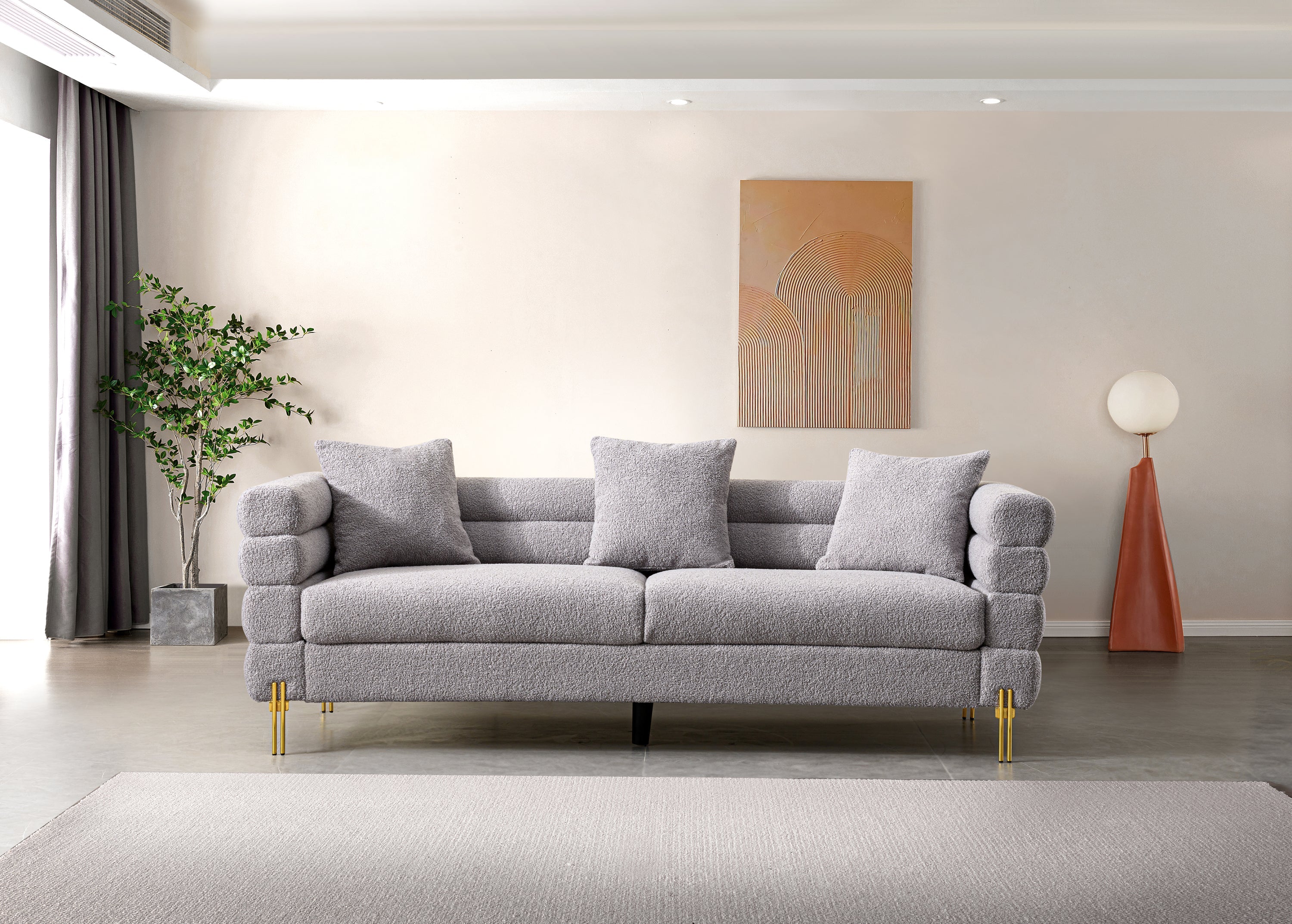 Luxurious and comfortable upholstered sofa with golden legs and pillows for living room and reception area