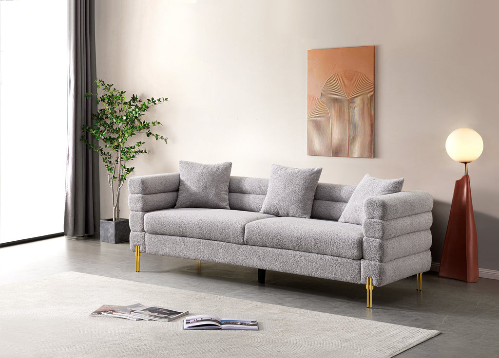 Luxurious and comfortable upholstered sofa with golden legs and pillows for living room and reception area